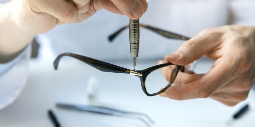 mężczyzna naprawiający oprawki okularowe